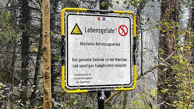 Im Waldgebiet beim ehemaligen Truppenübungsplatz weist ein Schild auf die Gefahren hin, die in diesem Bereich im Boden liegen.