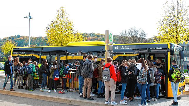 Hygieneregeln und Trennung von Klassen in der Schule, Traubenbildung an der Bushaltestelle: Ein Lehrer (links) achtet darauf, dass ...
