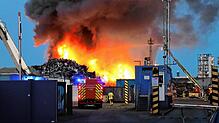 08.08.2025, Baden-Württemberg, Mannheim: Auf dem Gelände einer Recyclingsfirma im Industriehafen löscht die Feuerwehr einen brennenden ...