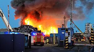 08.08.2025, Baden-Württemberg, Mannheim: Auf dem Gelände einer Recyclingsfirma im Industriehafen löscht die Feuerwehr einen brennenden ...