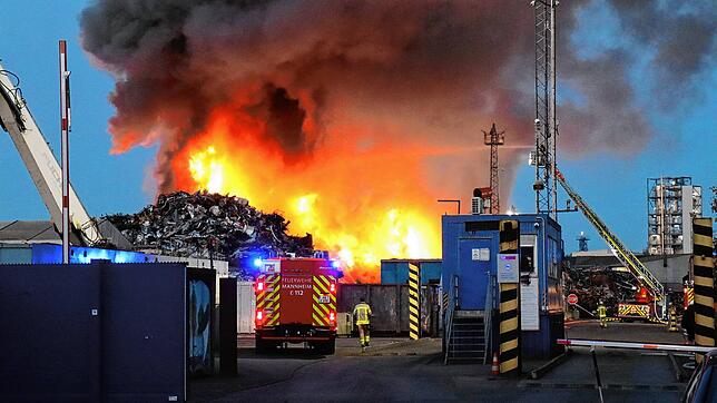 08.08.2025, Baden-Württemberg, Mannheim: Auf dem Gelände einer Recyclingsfirma im Industriehafen löscht die Feuerwehr einen brennenden ...