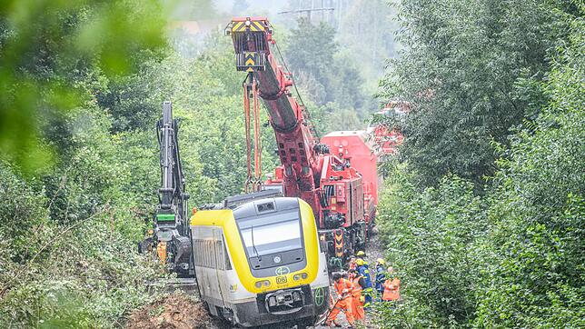 Mit einem Kran wird an der Unfallstelle, an der ein Regionalzug entgleist ist, gearbeitet. Ein Regionalexpress war am Sonntagabend ...