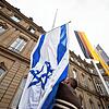 Die Flagge Israels wird von einem Mitarbeiter des Staatsministeriums in Stuttgart zwischen den Flaggen der EU, Deutschlands und ...