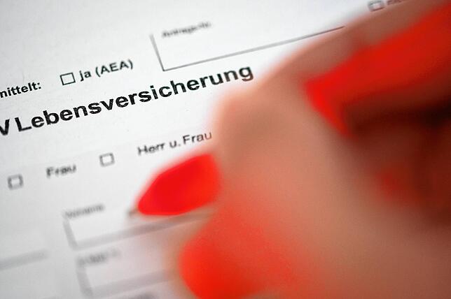 Eine Person füllt einen Antrag für das Abschließen einer Lebensversicherung zur Altersvorsorge aus.