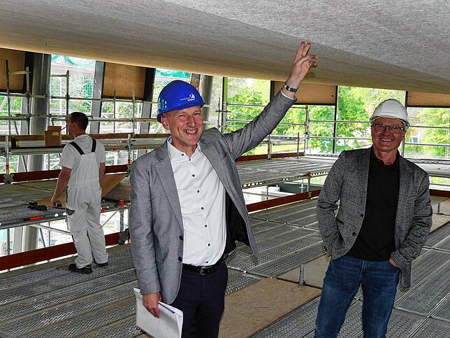In fast zehn Metern Höhe zeigt Bädergesellschaft-Geschäftsführer Robert Grammelspacher (Mitte) das kompliziert geplante Dach mit ...