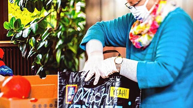 Eine Helferin packt Lebensmittel in Tüten für die Aktion Vespertüten. Bild: Christoph Brotz