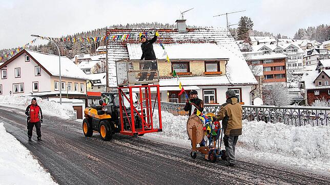 Mitglieder der Schonacher Narrenzunft schmücken die Straßen im Ort mit bunten Fasnetbändeln.