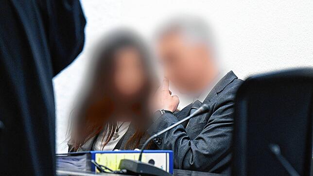 Der Angeklagte in einem Prozess um sexuelle Nötigung sitzt mit seiner Frau im Gerichtssaal.