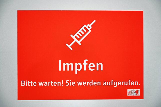 Ein Schild mit der Aufschrift „Impfen – Bitte warten! Sie werden aufgerufen.“: Treffender könnte es nicht sein. Immer ...