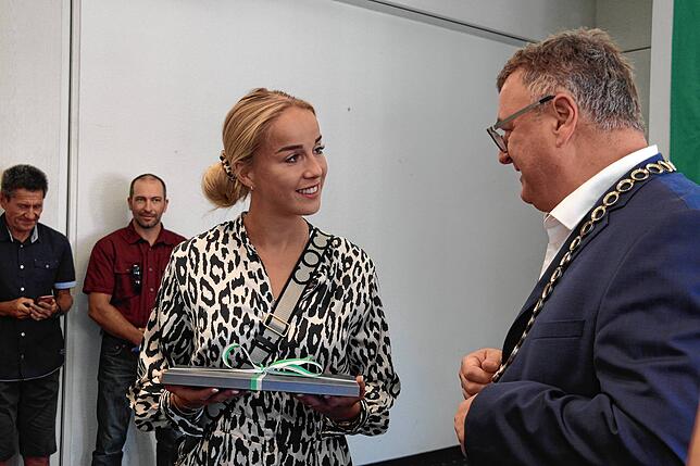 Ab in die Lüfte: Friedrichshafens Oberbürgermeister Andreas Brand überreicht Fußballstar Giulia Gwinn eine Gutschein für einen Flug mit ...