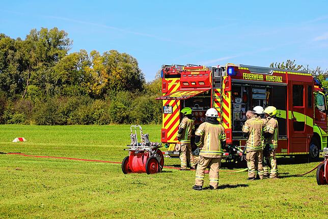 Kräfte der Feuerwehr holen die Schläuche aus den Einsatzfahrzeugen.