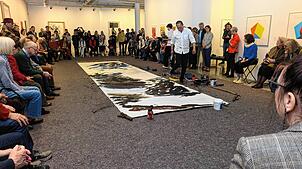 Xianwhei Zhu arbeitet im Kunstmuseum Singen umrahmt vom Publikum an einer abstrakt-gegenständlichen Basis aus Schwarz-, Grau- und ...