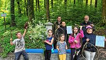Kinder und Förster präsentieren ihre kreativen Werke aus dem Workshop „Kunst im Wald“. Foto: Melanie Schweizer
