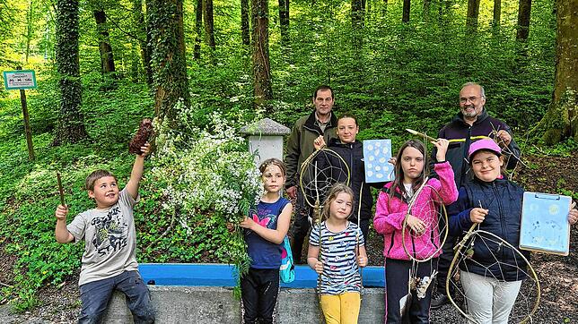 Kinder und Förster präsentieren ihre kreativen Werke aus dem Workshop „Kunst im Wald“. Foto: Melanie Schweizer