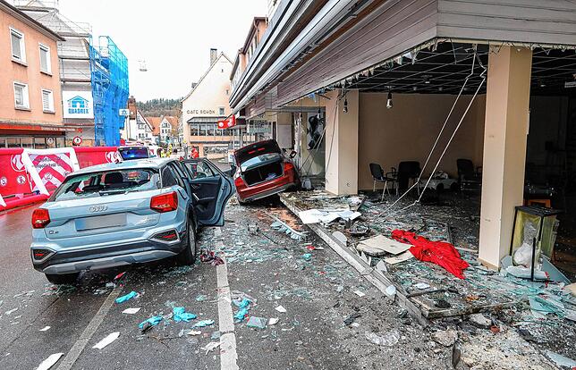 Das demolierte Auto (r) steht in der Innenstadt in einem Schaufenster, ein zweites Fahrzeug ist beschädigt worden.