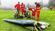In Vorarlberg ist ein Kleinflugzeug abgestürzt. Einsatzkräfte arbeiten hinter einem Flugzeugteil.