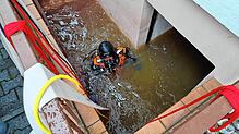 Ein Taucher im vollgelaufenen Kellerabgang: Damit das Wasser-Öl-Gemisch nicht in die Schussen läuft, sucht er den Ort, an dem hier ...