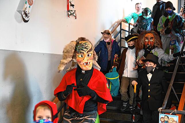 Eine Wurzelhexe und ein Erzknappe führen die Schüler aus dem Schulgebäude.
