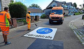 Im Schießstattweg werden am Donnerstagvormittag auf der Fahrbahn die Piktogramme aufgebracht.