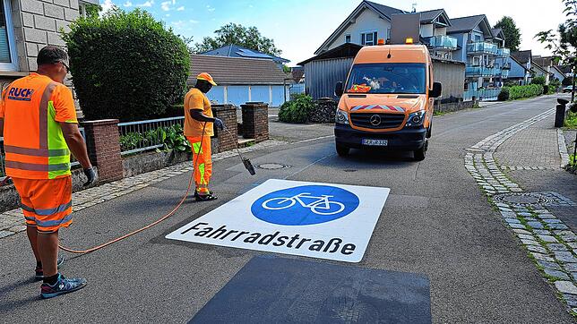 Im Schießstattweg werden am Donnerstagvormittag auf der Fahrbahn die Piktogramme aufgebracht.
