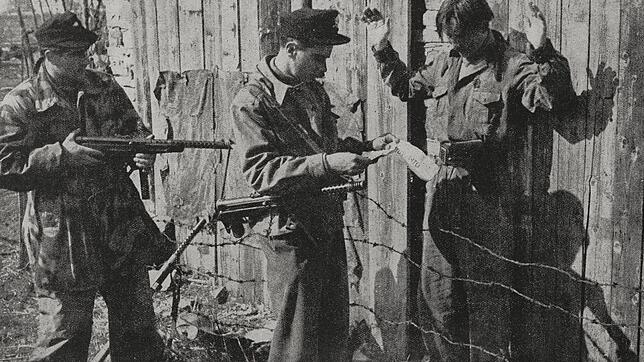 Soldaten kontrollieren 1944 in Slowenien  einen Partisanen (r.). Bild: Luce Mantovan/Bibliothek DeAgostini/Getty Images