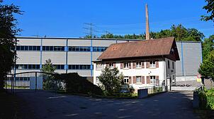 Das historische Mühlengebäude vor der Murger Produktionshalle der Global Safety Textiles verrät, dass es sich hie rum einen Jahrhunderte ...