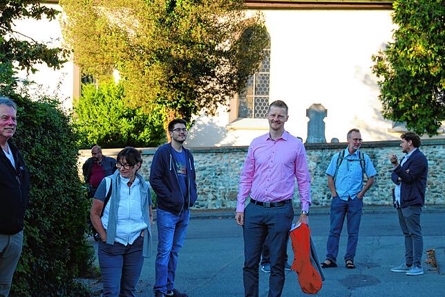 Vor dem Start der Zuhörtor in Markelfingen: OB-Kandidat Simon Gröger (Mitte) begrüßt vor dem Rathaus die Teilnehmer.