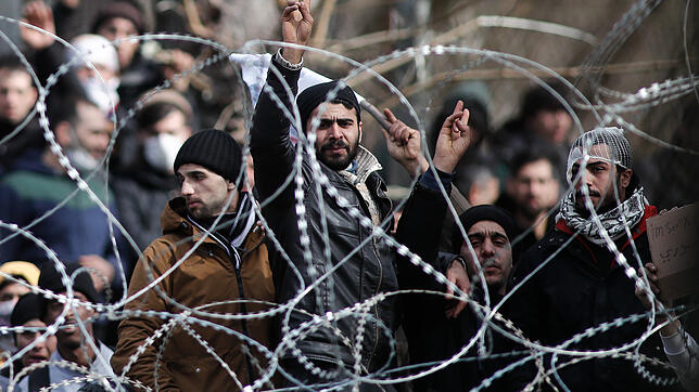 Migranten an der griechisch-türkischen Grenze Migranten und Flüchtlinge versammeln sich hinter einem Drahtzaun an der Grenze zwischen Griechenland und der Türkei in der Nähe des ...