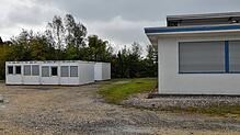 Links stehen schon die ersten Container, in denen 20 Flüchtlinge unterkommen sollen. Rechts im Bild ist ein Teil des Gebäudes der Firma ...