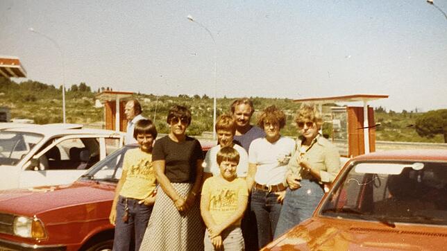 Kerstin Skodell direkt neben dem VW Golf. Daneben sind ihre Freundin und ein Teil beider Familien zu sehen.