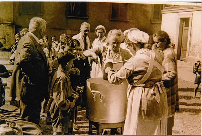 Bei einer Schülerspeisung wird nach dem Krieg Essen ausgegeben.