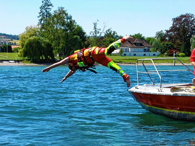 DLRG-Rettungsschwimmer Simon Büche hechtet in der Nähe des Schweizer Ufers in den See um einen ohnmächtigen Wassersportler zu bergen.