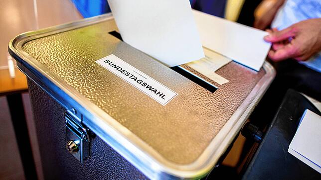 Ein Wähler wirft in einem Wahllokal seinen Stimmzettel für die Bundestagswahl in eine Wahlurne (Hier ein Symbolbild).