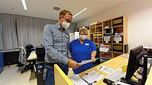 Maximilian Bosch, Verantwortlicher für das Belegungsmanagement im Krankenhaus, und Kollegin Heike Schöllhorn beim analogen Arbeiten: Die ...