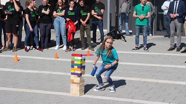 Svenja zieht einen Holzklotz, auf dem ein Wort steht, das ihr Projekt beschreibt.