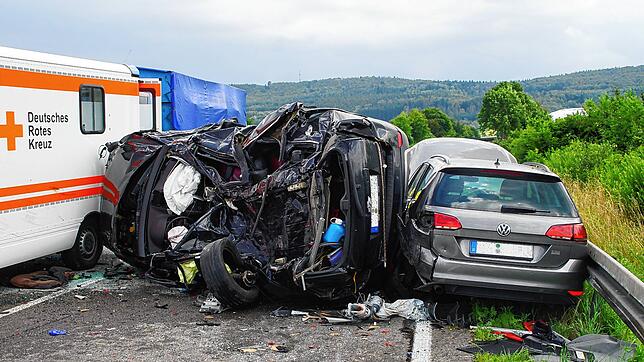 Ein völlig demoliertes Auto klemmt zwischen dem Rettungswagen und einem weiteren Fahrzeug. Für die Fahrerin kommt jede Hilfe zu spät.