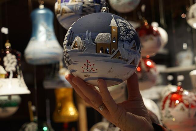 Die handbemalten Weihnachtskugeln sind ein besonderes Geschenk. Eine Schweizerin, ihr gehört die Hand, kauft diese Kugel für ihre Tochter.