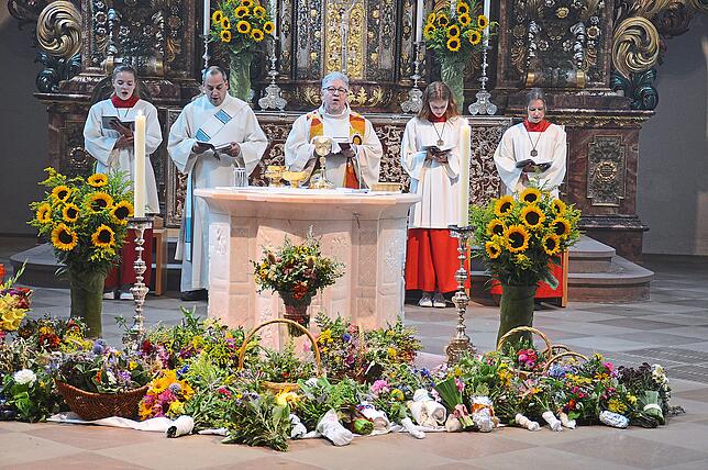 Viele Kräutersträußchen sind vor dem Altar der Wallfahrtskirche zur Segnung niedergelegt. Pfarrer Andreas Treuer (Mitte) segnet diese am ...