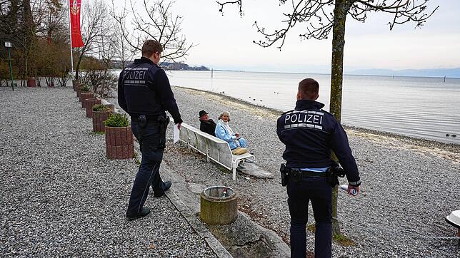 Zwei Beamte des Polizeireviers Friedrichshafen kontrollieren das wegen der Corona-Pandemie erlassene Aufenthaltsverbot in den Uferanlagen.