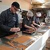 Rafael Mutter, Inhaber der Confiserie Mutter, mit zwei Mitarbeitern in den beengten Produktionsräumen in Obersäckingen.