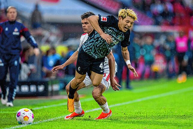 Kölns Max Finkgräfe (l) und Freiburgs Ritsu Doan versuchen an den Ball zu kommen.