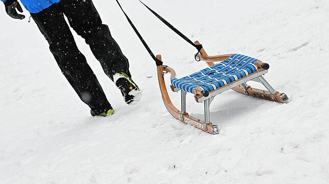 Ein Mann zieht seinen Schlitten über den Schnee (Symbolbild): Zu einem Unfall mit einem Verletzten ist es am Freitag auf einer Skipiste ...