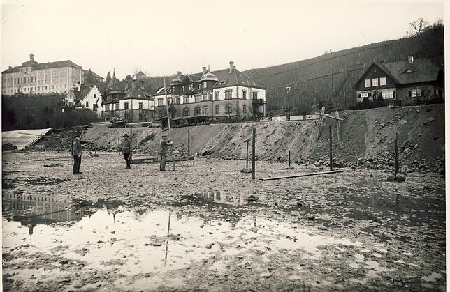 1933 wird daran gearbeitet, das Meersburger Strandbad anzulegen. Stabilisierende Pfähle ragen aus dem Erdboden, die Arbeiter schauen in ...