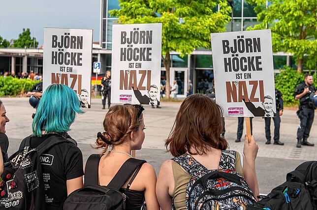 Demonstranten halten bei der Kundgebung gegen die AfD-Veranstaltung Schilder in die Höhe.