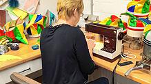 Eine Mitarbeiterin des Hutmacher-Fachbetriebs in Waldshut-Tiengen fertigt Laufnarrenkappen in Handarbeit. Bild: Narrengericht Stockach