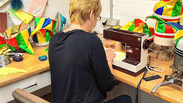 Eine Mitarbeiterin des Hutmacher-Fachbetriebs in Waldshut-Tiengen fertigt Laufnarrenkappen in Handarbeit. Bild: Narrengericht Stockach