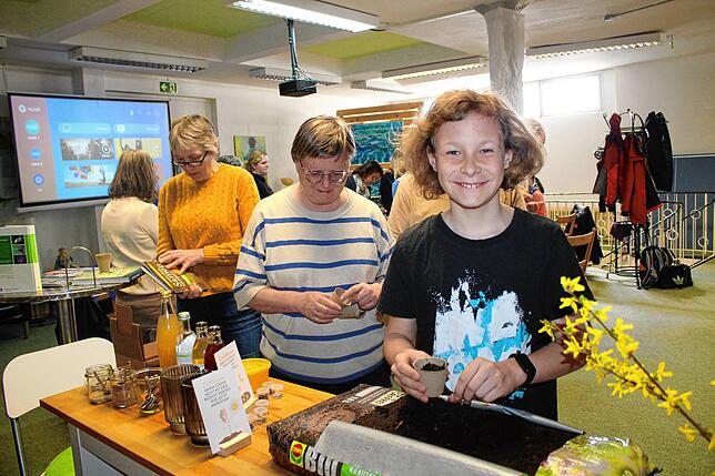 Ole Korn (rechts) ist der jüngste Workshop-Teilnehmer. Hier füllt er Aussaaterde in die kleinen Töpfe.