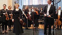 Chefdirigent Achim Fiedler (vorne rechts), seine Konzertmeisterin Marija Lauenstein (vorne links) und das Sinfonieorchester ...