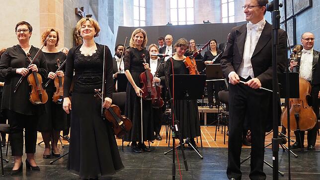 Chefdirigent Achim Fiedler (vorne rechts), seine Konzertmeisterin Marija Lauenstein (vorne links) und das Sinfonieorchester ...