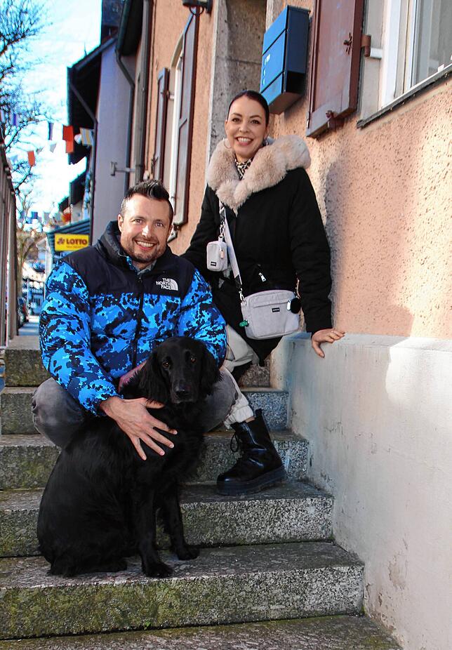 Mike und Kristina Holding gemeinsam mit Hündin Nuki auf der Treppe vor ihrem neuen Geschäft in der Hauptstraße.